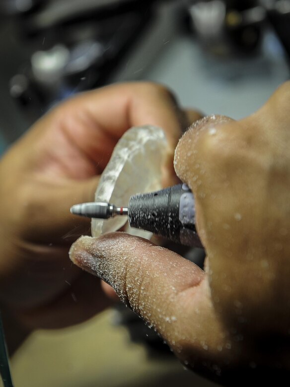Tech Sgt. Antwon Mcphail, a dental laboratory technician with the 1st Special Operations Dental Squadron, shapes a mouth guard at Hurlburt Field, Fla., April 18, 2016. The dental laboratory creates mouth appliances for patients prescribed by the dentists. Appliances may be permanent or removable depending on the treatment plan. (U.S. Air Force photo by Senior Airman Meagan Schutter)