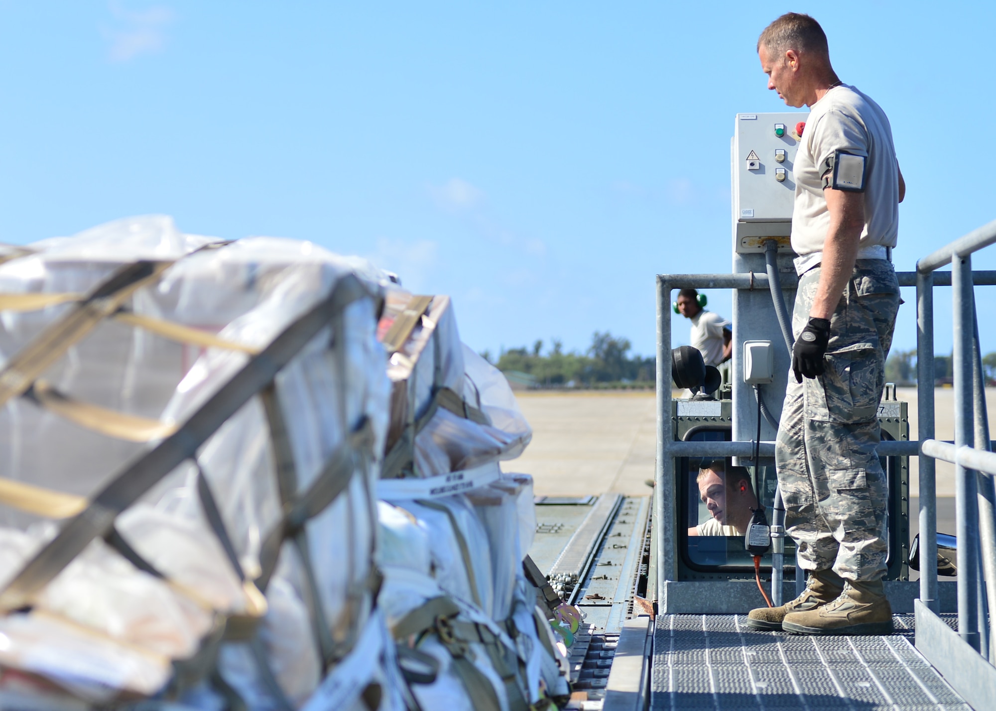 Tech. Sgt Shawn Kane (front) and Senior Airman Sean Newkirk, both Air Force Reservists from the 32nd Aerial Port Squadron, Pittsburgh Air Reserve Station, are spotters as a pallet is loaded on a Tunner Loader operated by Senior Airman Matthew Worry, an Air Force Reservist from the 32nd Aerial Port Squadron, Pittsburgh Air Reserve Station, on Joint Base Pearl Harbor-Hickam, April 14, 2016. Approximately 30 Airmen from the 32nd APS traveled to JBPHH to conduct annual training hosted by the Airmen of the 735th Air Mobility Squadron. (U.S. Air Force photo by Tech. Sgt. Aaron Oelrich)