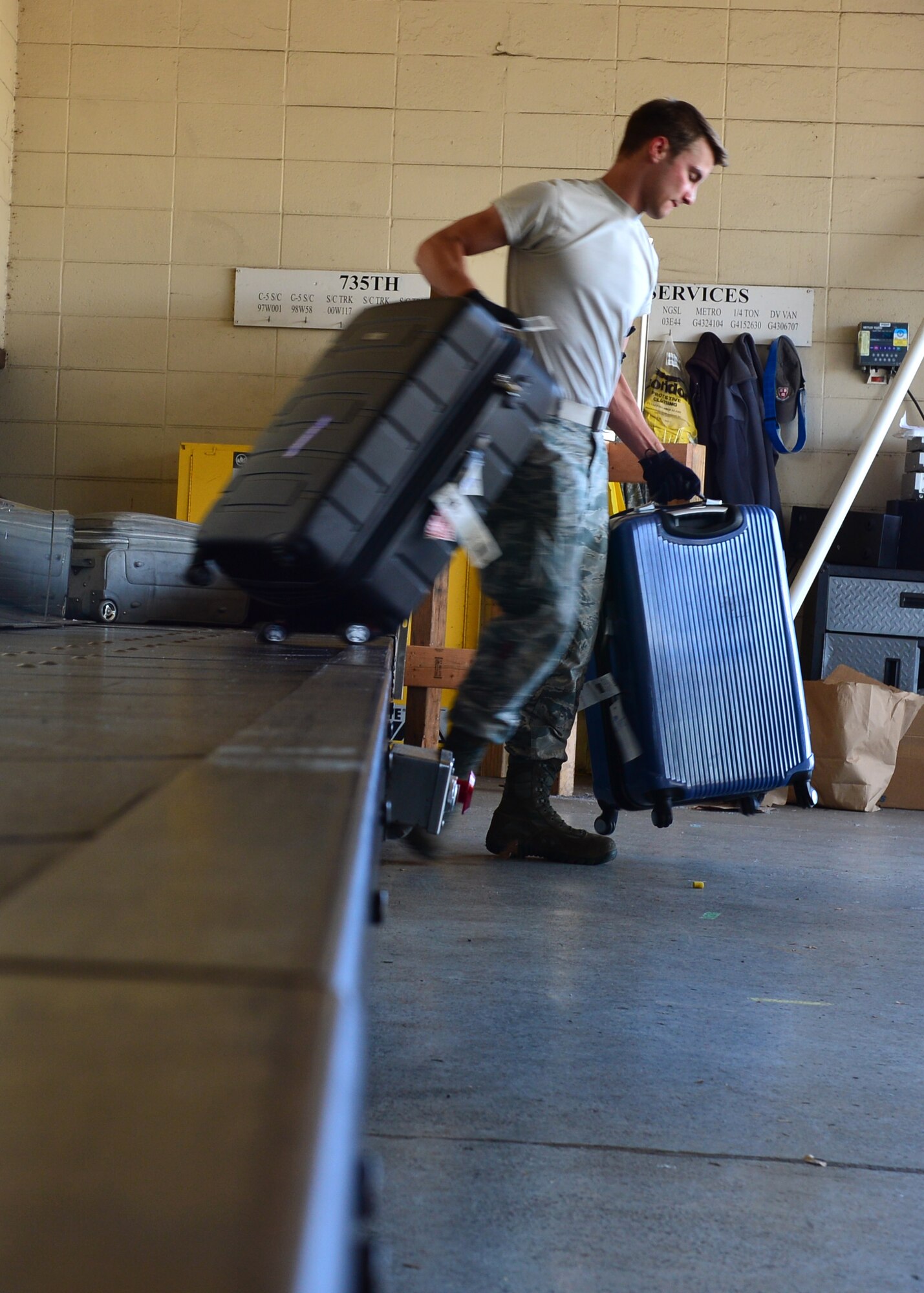 Senior Airman Patrick Lokhaiser, an Air Force Reservist from the 32nd Aerial Port Squadron, Pittsburgh Air Reserve Station, moves luggage from a conveyor belt to a pallet to be loaded on an aircraft on Joint Base Pearl Harbor-Hickam, April 14, 2016. Approximately 30 Airmen from the 32nd APS traveled to JBPHH to conduct annual training hosted by the Airmen of the 735th Air Mobility Squadron. (U.S. Air Force photo by Tech. Sgt. Aaron Oelrich/Released)