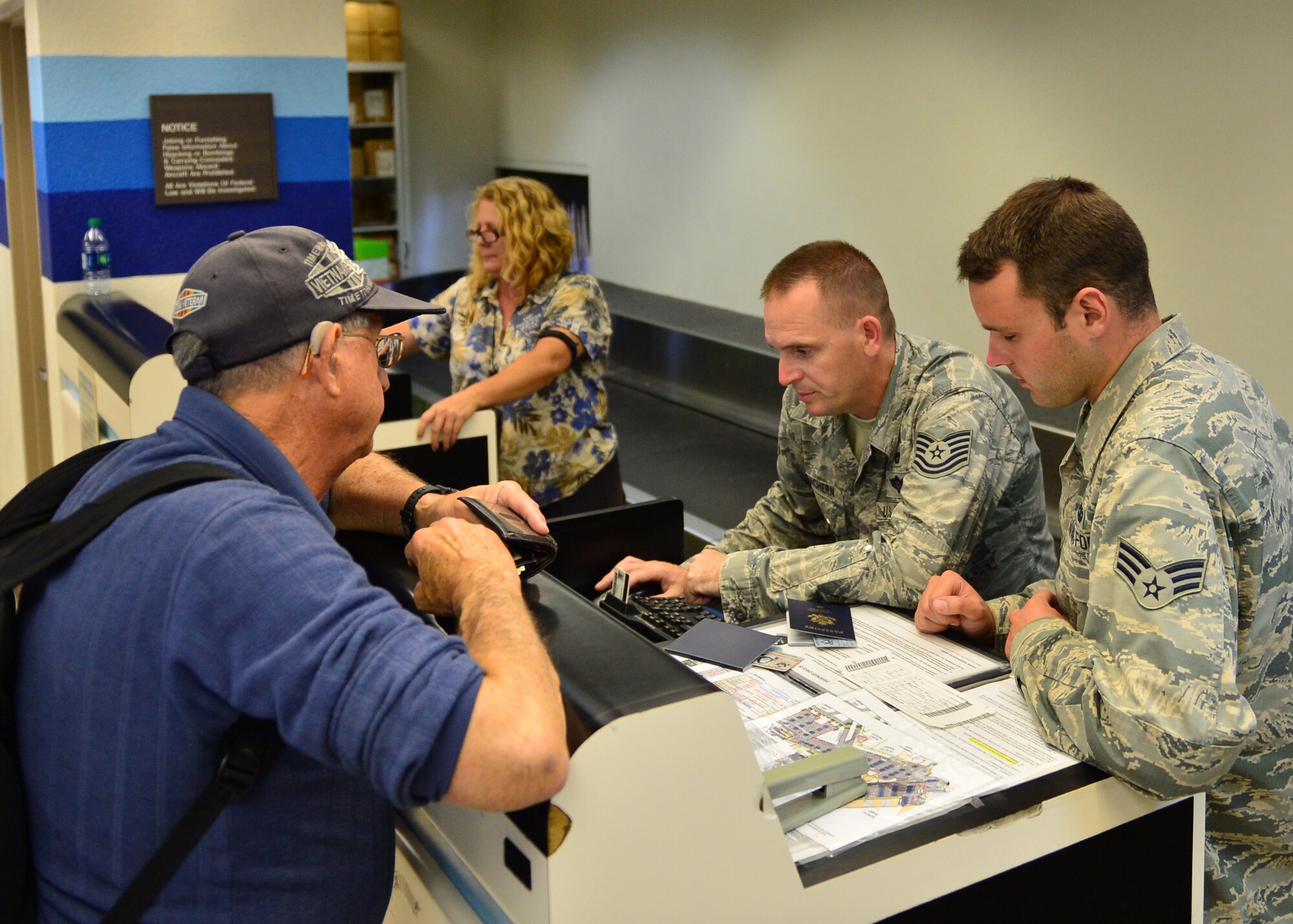 Tech. Sgt. Tom McEachern and Senior Airman Brice Safreed, both Air Force Reservists from the 32nd Aerial Port Squadron, Pittsburgh Air Reserve Station, issue a boarding pass to a passenger on Joint Base Pearl Harbor-Hickam, April 14, 2016. Approximately 30 Airmen from the 32nd APS traveled to JBPHH to conduct annual training hosted by the Airmen of the 735th Air Mobility Squadron. (U.S. Air Force photo by Tech. Sgt. Aaron Oelrich/Released)