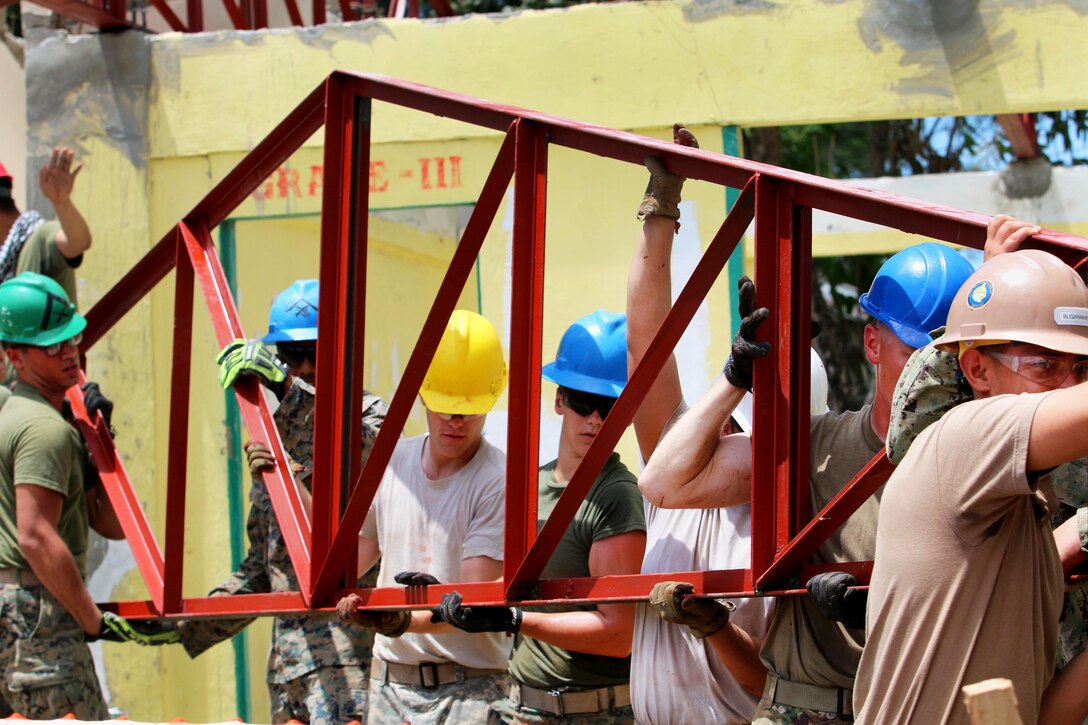 Service members lift a truss to restore a damaged classroom at Matangharon Elementary School, Barangay Matangharon, Philippines, as part of Exercise Balikatan, April 3, 2016. The school was damaged during last year’s typhoon and is one of multiple humanitarian and civic assistance projects that demonstrate the commitment to training, cooperation and interoperability between the Philippines and the U.S. The annual bilateral exercise allows service members from both countries to train and enhance human assistance and disaster relief capabilities. Army photo by Staff Sgt. Chanelcherie K. DeMello