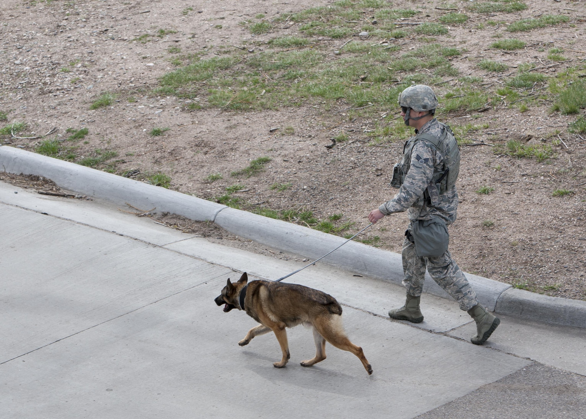 A 90th Security Forces Squadron military dog handler and his K-9 conduct perimeter securty sweeps during an exercise on F.E. Warren Air Force Base, Wyo., April 15, 2016. Training for possible real world scenarios keep 90th Missile Wing defenders ready for security incidents that can pose a threat to base personnel. (U.S. Air Force Photo by Lan Kim)