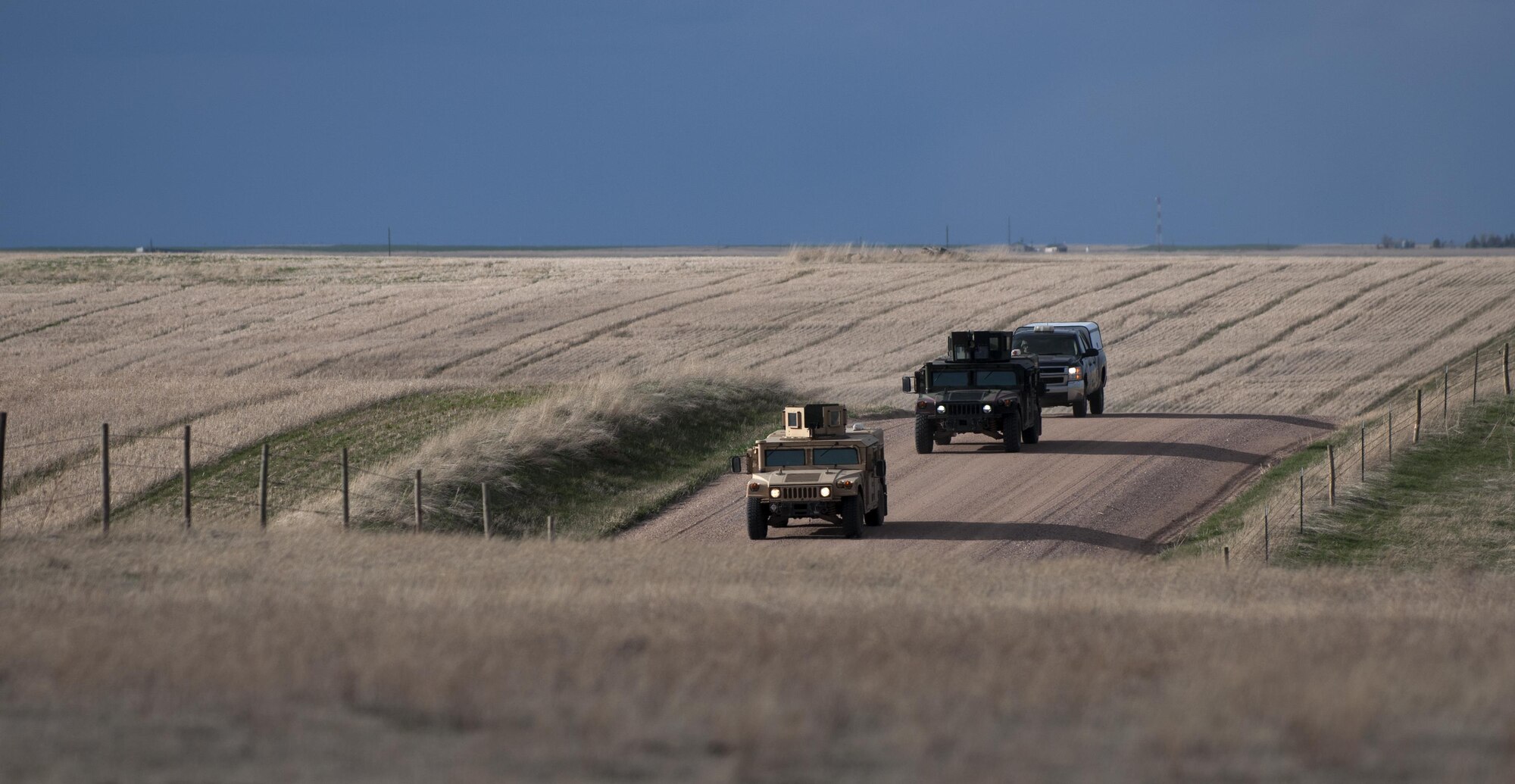 Humvees filled with security forces defenders from the 90th Security Forces Group drive down a gravel road toward one of the 90th Missile Wing’s launch facilities April 14, 2016, in the F.E. Warren Air Force Base, Wyo., Missile Complex. Constant Vigilance is an annual Air Force Global Strike Command exercise designed to train and assess the command’s ability to support its conventional and nuclear missions. (U.S. Air Force photo by Senior Airman Brandon Valle)