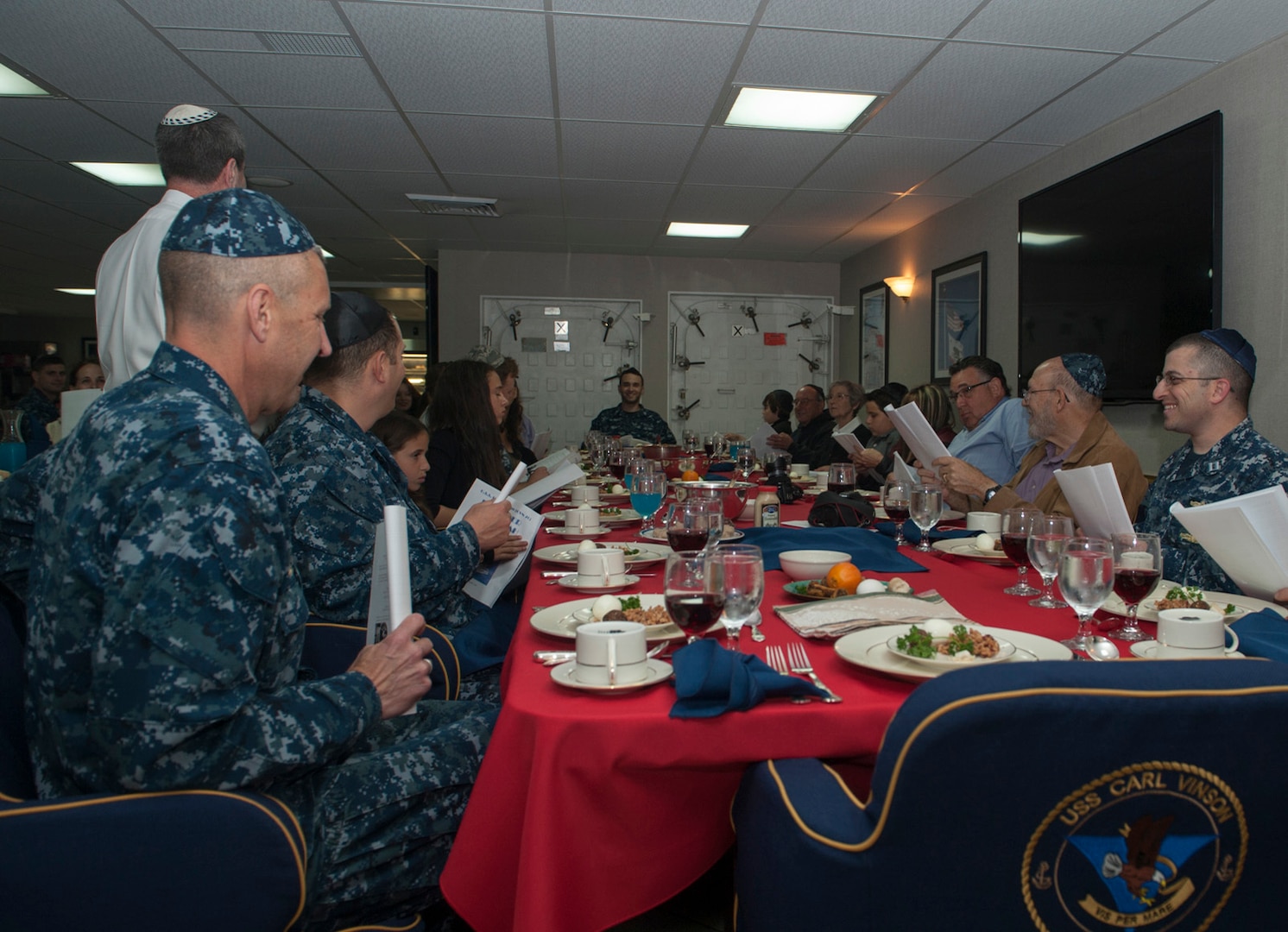 Sailors and family members participate in the Passover Seder meal aboard aircraft carrier USS Carl Vinson April 15, 2015. Jewish military members around the world can have a traditional Seder meal and observe Kosher during Passover, thanks to DLA Troop Support. 