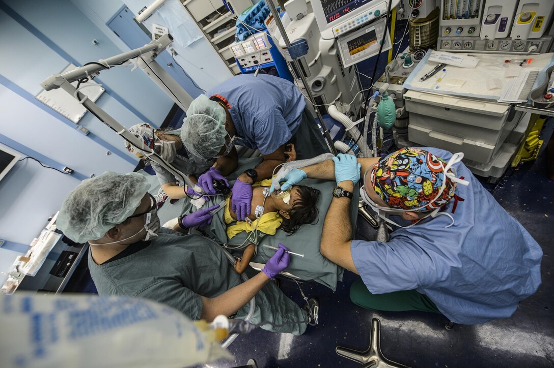 Combat Operations: U.S. Service members perform a fractional CO2 laser procedure on a child during Pacific Partnership 2015 aboard the USNS Mercy in the Pacific Ocean, Aug. 1, 2015. During the procedure, tiny holes are made into the skin to allow collagen regrowth leading to healthier skin and increased mobility. Navy photo by Petty Officer 2nd Class Mark El-Rayes