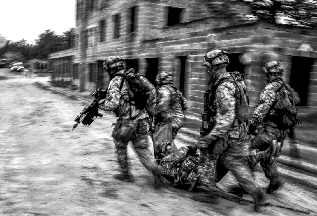 Combat Training:  Army soldiers carry an injured soldier during a training exercise at Fort Bragg, N.C., April 15, 2015. The exercise tested the soldiers' abilities to successfully conduct a mission, complete the objective and rapidly evacuate casualties. The soldiers are assigned to the 2nd Brigade Combat Team, 82nd Airborne Division. U.S. Air Force photo by Senior Airman Marianique Santos