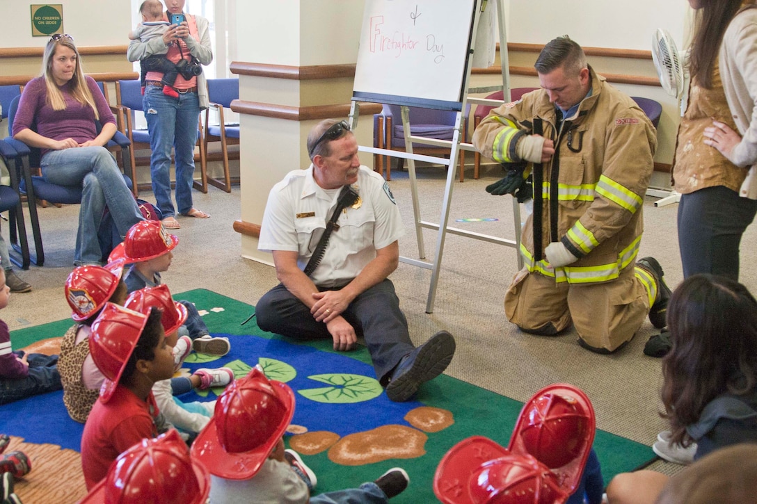 Stephen Williams, firefighter in Quantico Fire Station 531, shows a room full of toddlers a real firefighter suit during toddler story time.