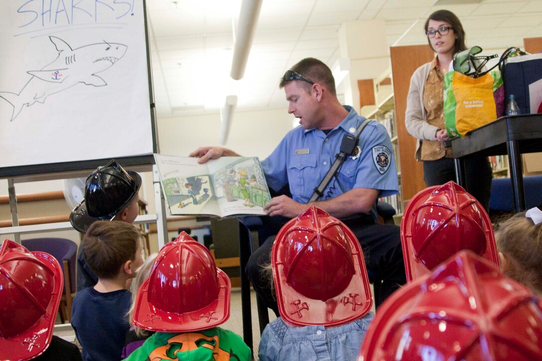 Firefighter medic, Robert Stargel, Quantico Fire Station 531, reads a book to children.