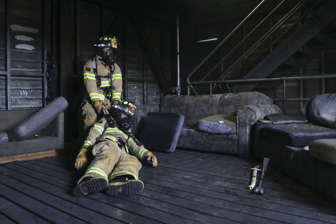 Airmen simulate recovering incapacitated firefighters during firefighting drills in the live-fire simulator at Joint Base Elmendorf-Richardson, Alaska, April 13, 2016. Air Force photo by Alejandro Pena