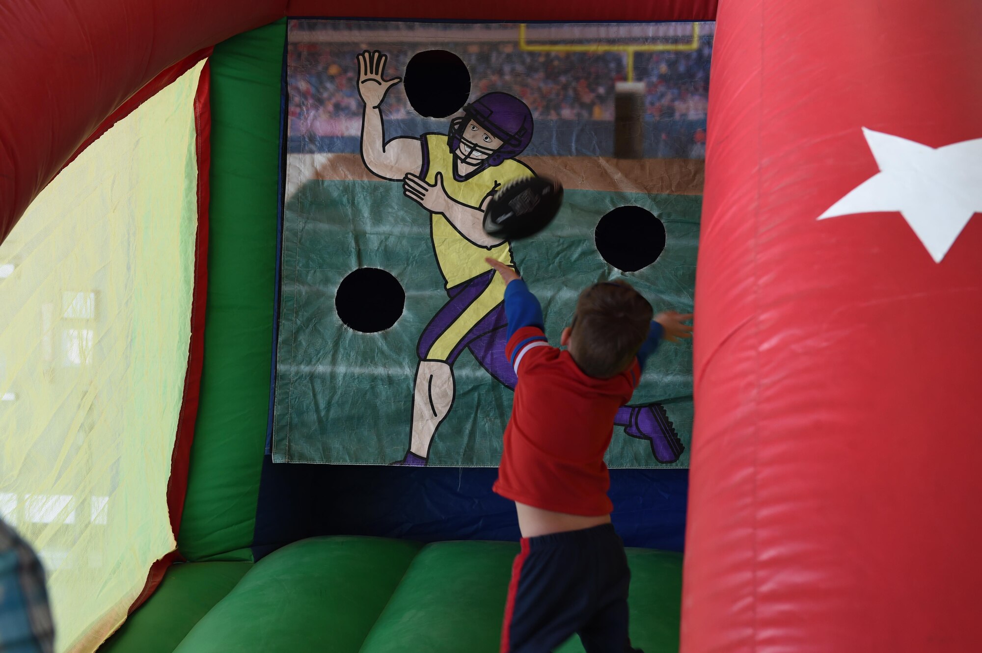 A child of Team Creech throws a football April 16, 2016, at Creech Air Force Base, Nevada. The Spring Fling event helped bring comradery and raised moral amongst Creech members and its spouses. (U.S. Air Force photo by Senior Airman Adarius Petty/Released)