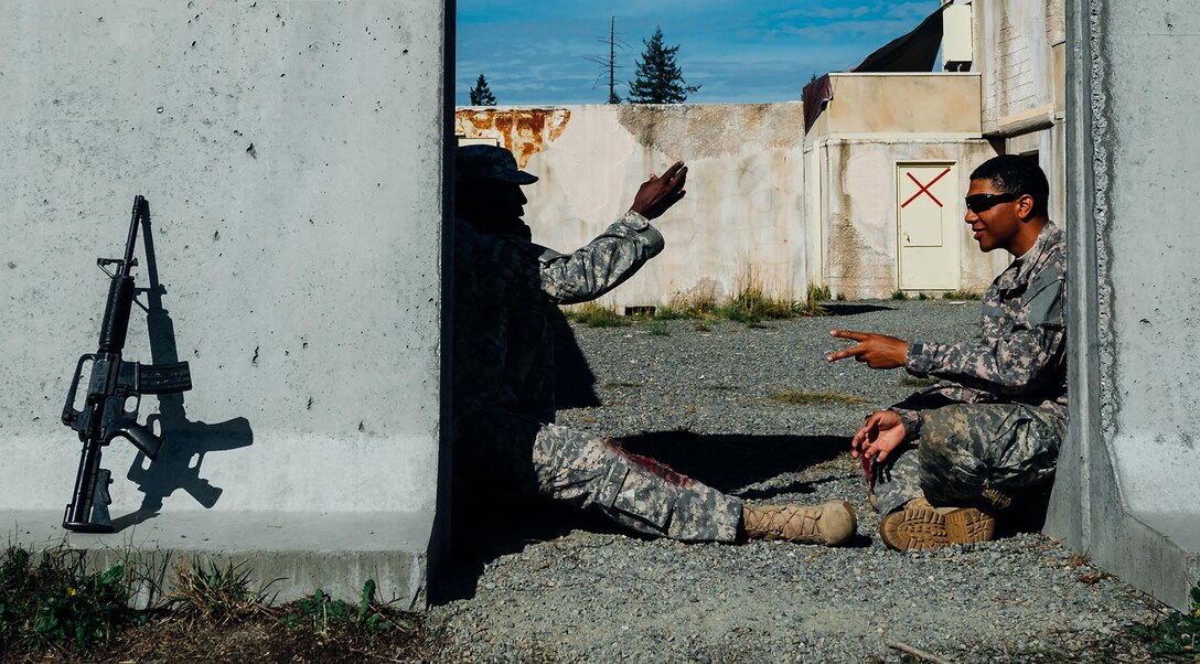 Features: Two soldiers make a decision by playing rock-paper-scissors before testing starts during the Expert Field Medic Badge course at Joint Base Lewis-McChord, Wash., Sept. 24, 2015. Every year airmen and soldiers attempt to pass the EFMB course where less than 20 percent of all candidates leave successful. U.S. Air Force photo by Senior Airman Jordan A. Castelan