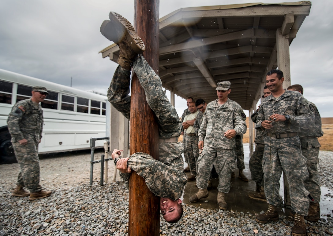 Features: Army Reserve combat engineer soldiers take a break in the rain while waiting for their rappelling training to resume as part of a Sapper Leader Course Prerequisite Training at Camp San Luis Obispo Military Installation, Calif., July 19, 2015. The unit is grading soldiers on various events to determine which ones will earn a spot on a merit list to attend the Sapper Leader Course at Fort Leonard Wood, Mo.  from the 374th Engineer Company, headquartered  in Concord, Calif. U.S. Army photo by Master Sgt. Michel A. Sauret