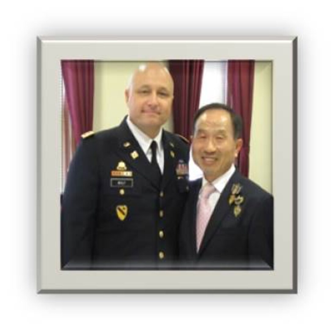 DLA Distribution Korea commander Army Lt. Col. Mark Wolf, left,  poses for a picture during Sang-Hwan So’s retirement ceremony in March 2016.