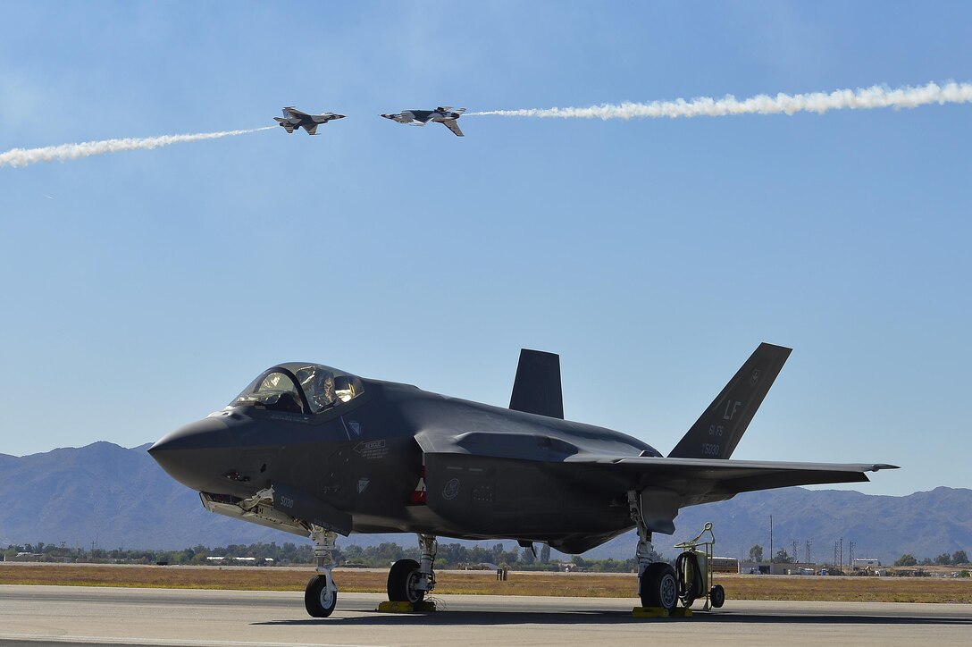 Air Force Capt. Nicholas Eberling and Air Force Maj. Alex Turner perform a manuever called the knife-edge pass over an F-35A Lightning II that was sitting on display at Luke Air Force Base, Ariz., April 3, 2016. Air Force photo by Tech. Sgt. Christopher Boitz
