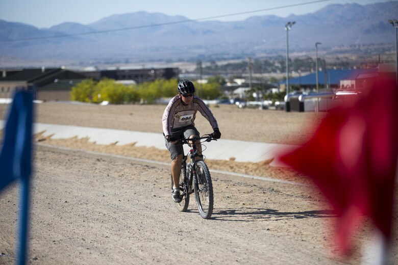 Jesse Santana, tank mechanic, Exercise Support Division, finishes first during the Annual Earth Day Mountain Bike Ride held near Range 100 aboard the Combat Center April 13, 2016. The eight-mile bike ride began and ended at Range 100. (Official Marine Corps photo by Cpl. Julio McGraw/Released)