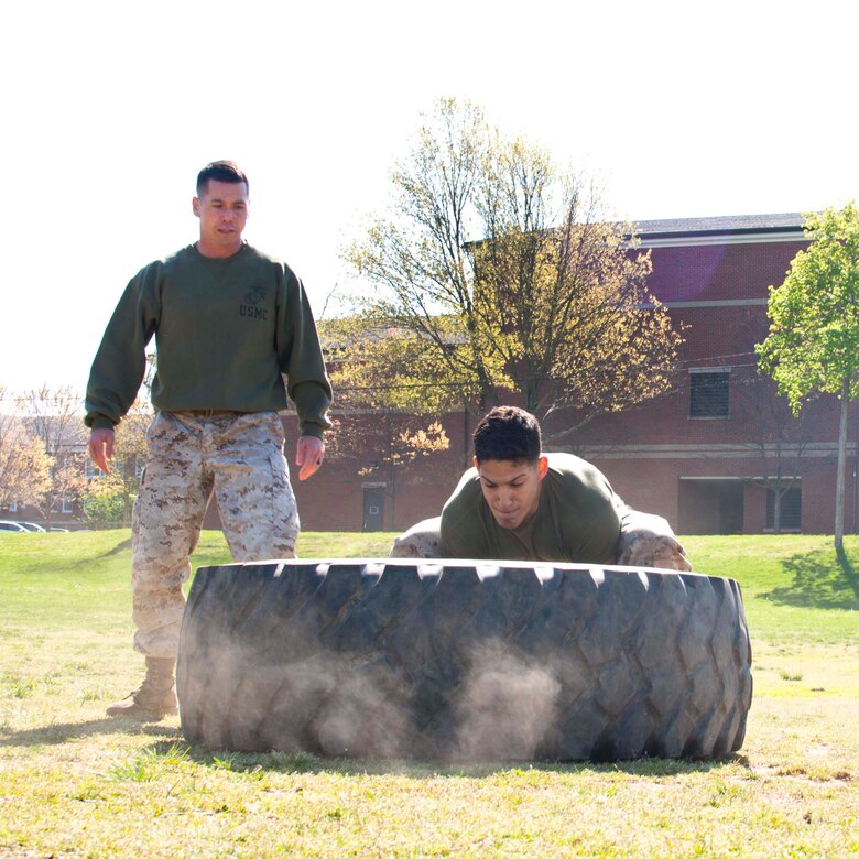 A team of two Marines flip a tractor tire.