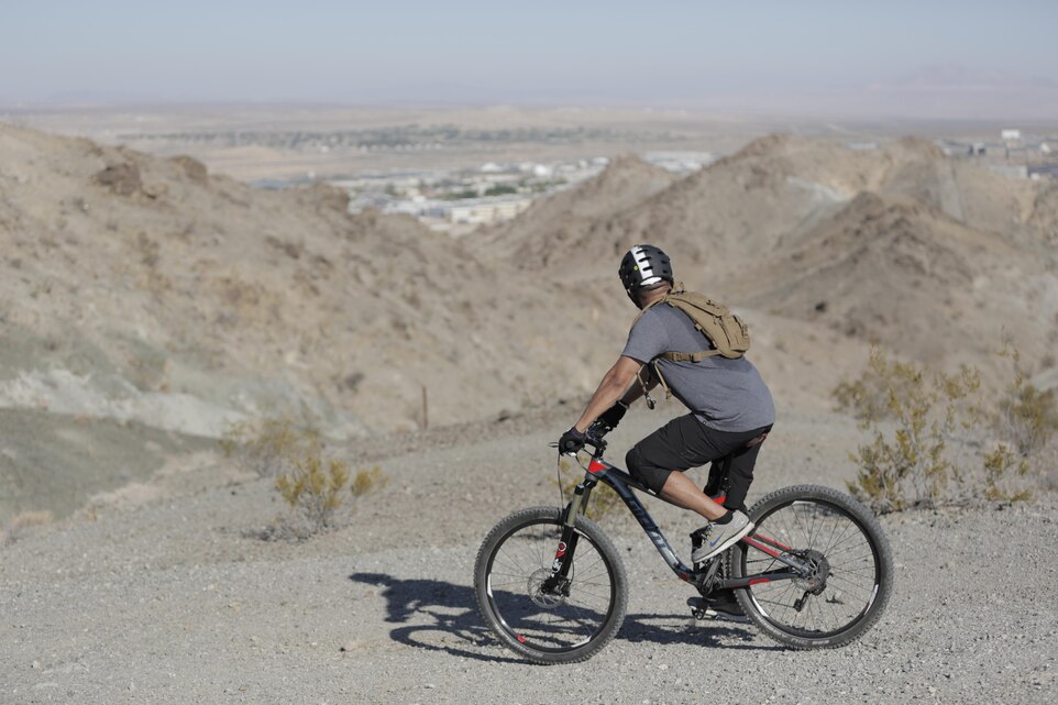 A rider observes his progress during the Annual Earth Day Mountain Bike Ride held near Range 100 aboard the Combat Center April 13, 2016. The eight-mile ride started at Range 100 and took participants through designated trails behind the range.  (Official Marine Corps photo by Pfc. Dave Flores/Released)