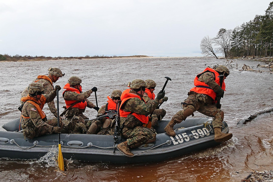 Soldiers prepare to exit an inflatable boat, unload gear and provide security during combat boat training at Adazi Military Base, Latvia, April 20, 2016. The soldiers are assigned to Headquarters and Headquarters Troop, 3rd Squadron, 2nd Cavalry Regiment. Latvian soldiers led the training as a part of Summer Shield XIII, a two-week exercise involving troops from the U.S., Latvia, Canada, Lithuania and Germany. Army photo by Sgt. Paige Behringer