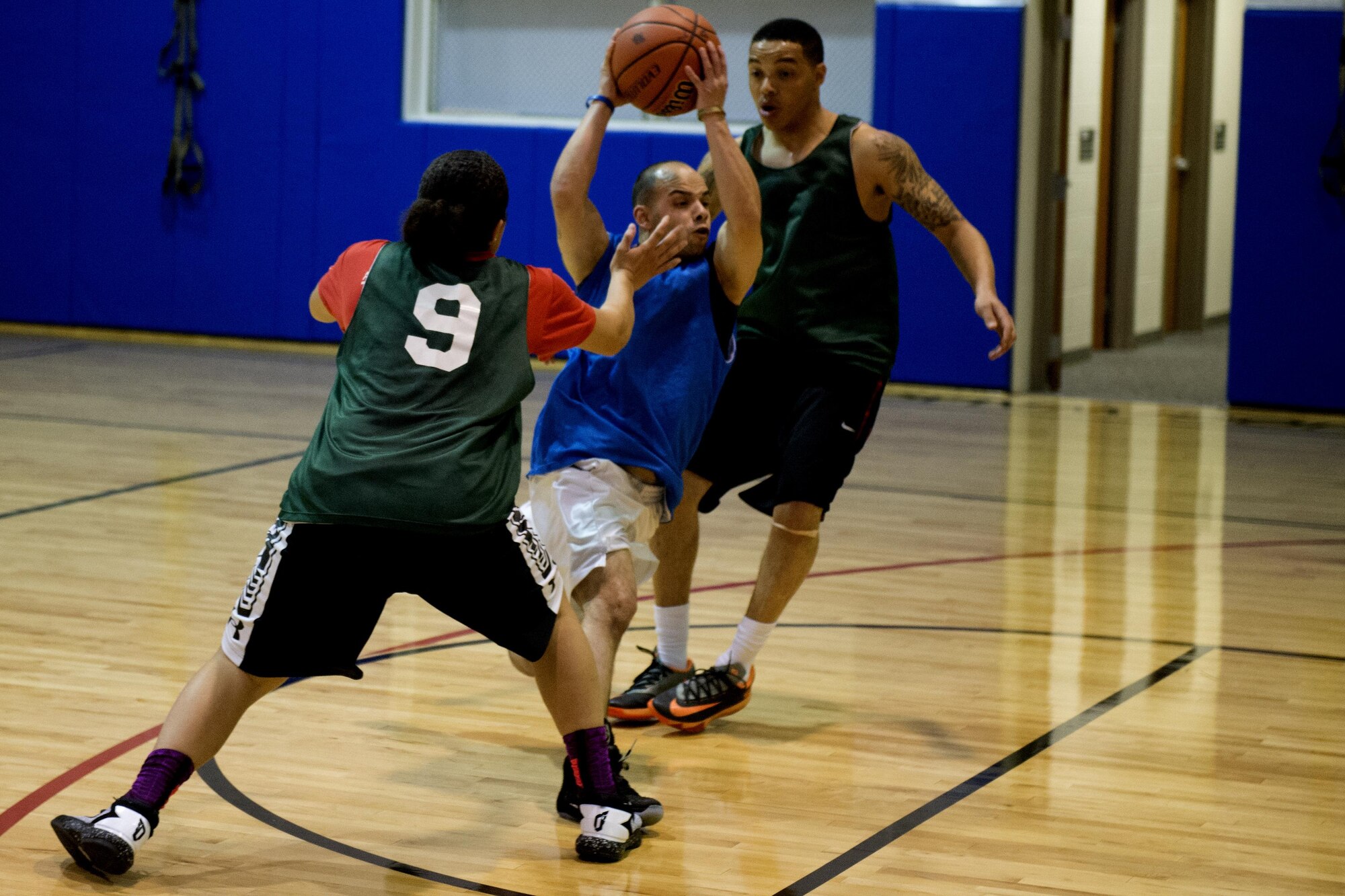 Mario Cruz, 434th Security Forces Squadron ‘A’ team, darts between players from the 434th Logistics Readiness Squadron team during the final game of the annual basketball tournament April 9, 2016 at Grissom Air Reserve Base, Ind. SFS and LRS were neck and neck until the final moments of the game before LRS pulled away to win 36-32. (U.S. Air Force photo/Senior Airman Dakota Bergl)