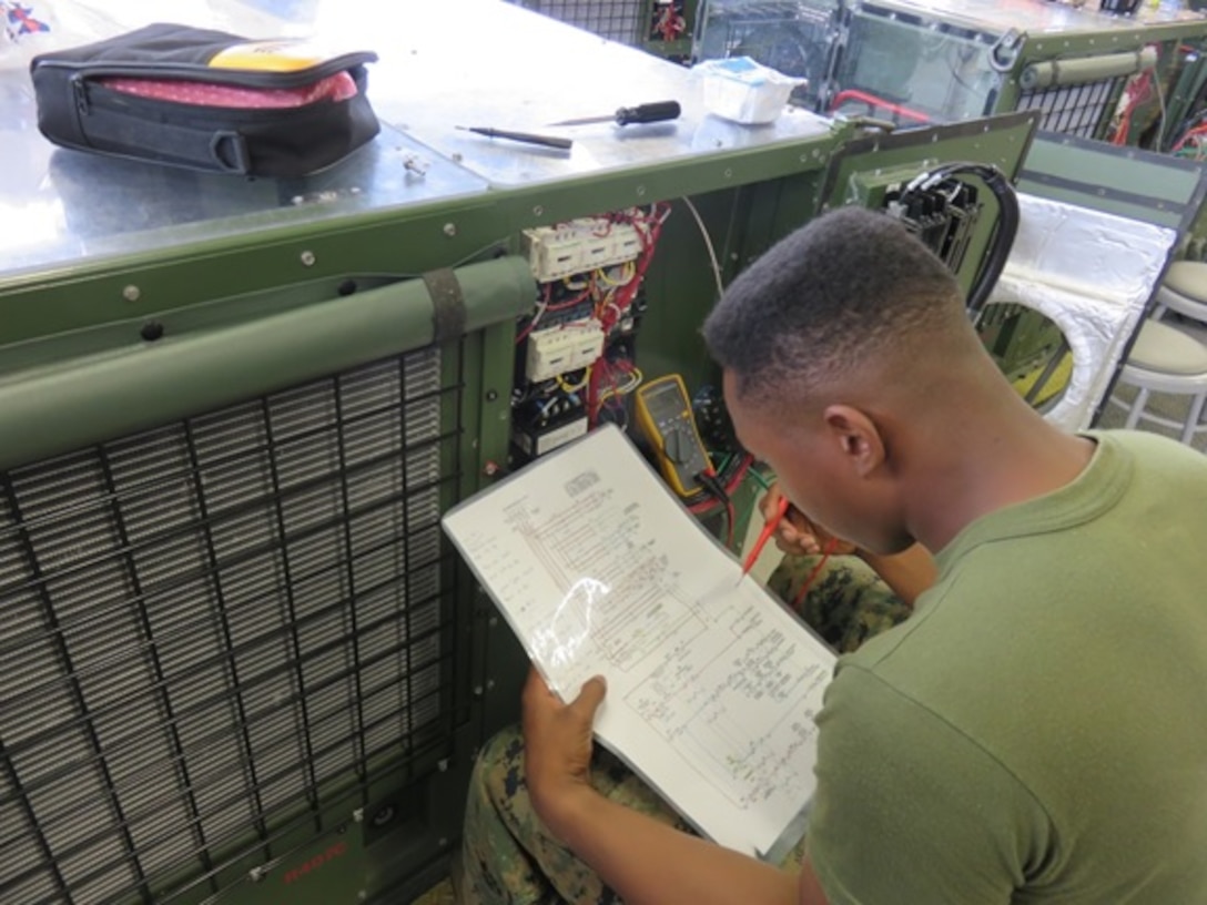 A Marine attached to the Basic Refrigeration and Air Conditioning Technician course 2-16 (BRACT 2-16) uses a schematic to help him troubleshoot an Environmental Control Unit (ECU) at Marine Corps Engineer School Courthouse Bay Camp Lejeune, N.C. 
