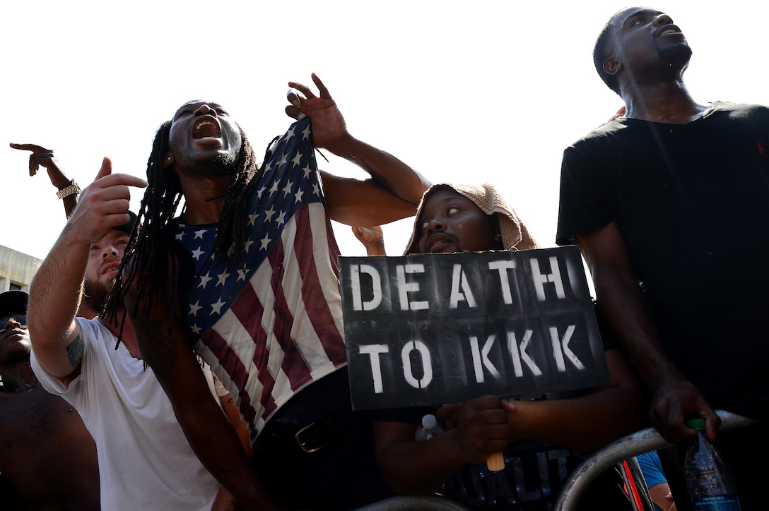 News: Dueling demonstrators clash as the Klu Klux Klan holds a protest rally on the steps of the South Carolina State House building at the same time as a New Black Panther Party rally also attended by other black activist groups in Columbia, S.C., July 19, 2015. The KKK held the rally to protest the removal of the Confederate flag from the State House grounds. The flag was taken down July 10, 2015. The demonstrating groups nearly went head-to-head as both rallies concluded and ended up face-to-face in the streets of downtown Columbia. In this photo, young African-American men push past metal barricades which are the only thing between them and several KKK members as they shout at Klan members to leave or die. Air Force photo by Staff Sgt. Kenny Holston