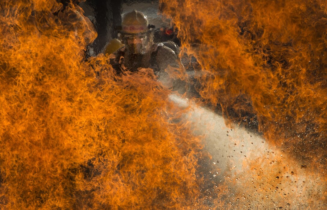 Military students battle a liquid fire during a training scenario at the Louis F. Garland Department of Defense Fire Academy at Goodfellow Air Force Base, Texas, Oct. 19, 2015. Air Force photo by Staff Sgt. Vernon Young Jr.