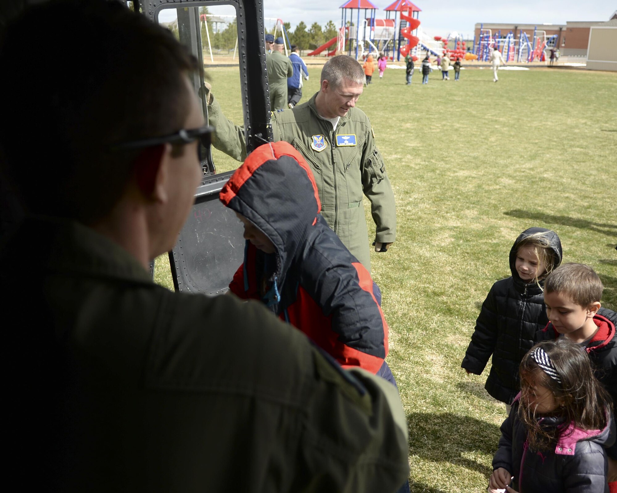 Airmen from the 37th Helicopter Squadron watch as children from Freedom Elementary School, Cheyenne, Wyo., check out a UH-1N Bell Helicopter April 20, 2016. The base and school faculty worked together in a joint effort to show the military children at the school how important they are. 