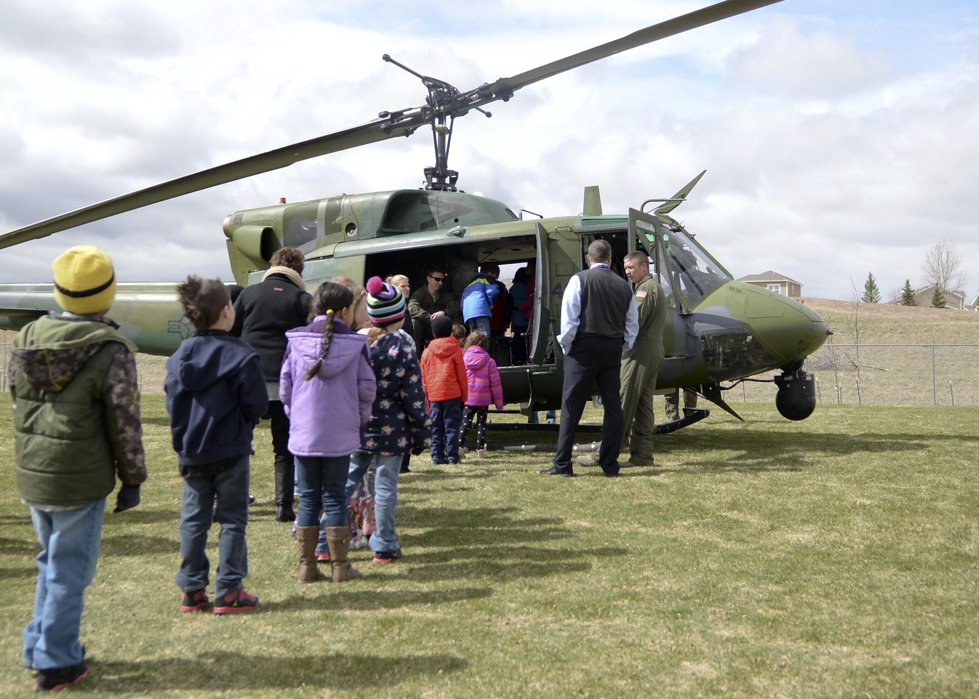 Children from Freedom Elementary School, Cheyenne, Wyo., line up to view one of the 37th Helicopter Squadron UH-1N Bell Helicopter April 20, 2016. Several dozen children were able to view the helicopter and have their questions answered by the crew.