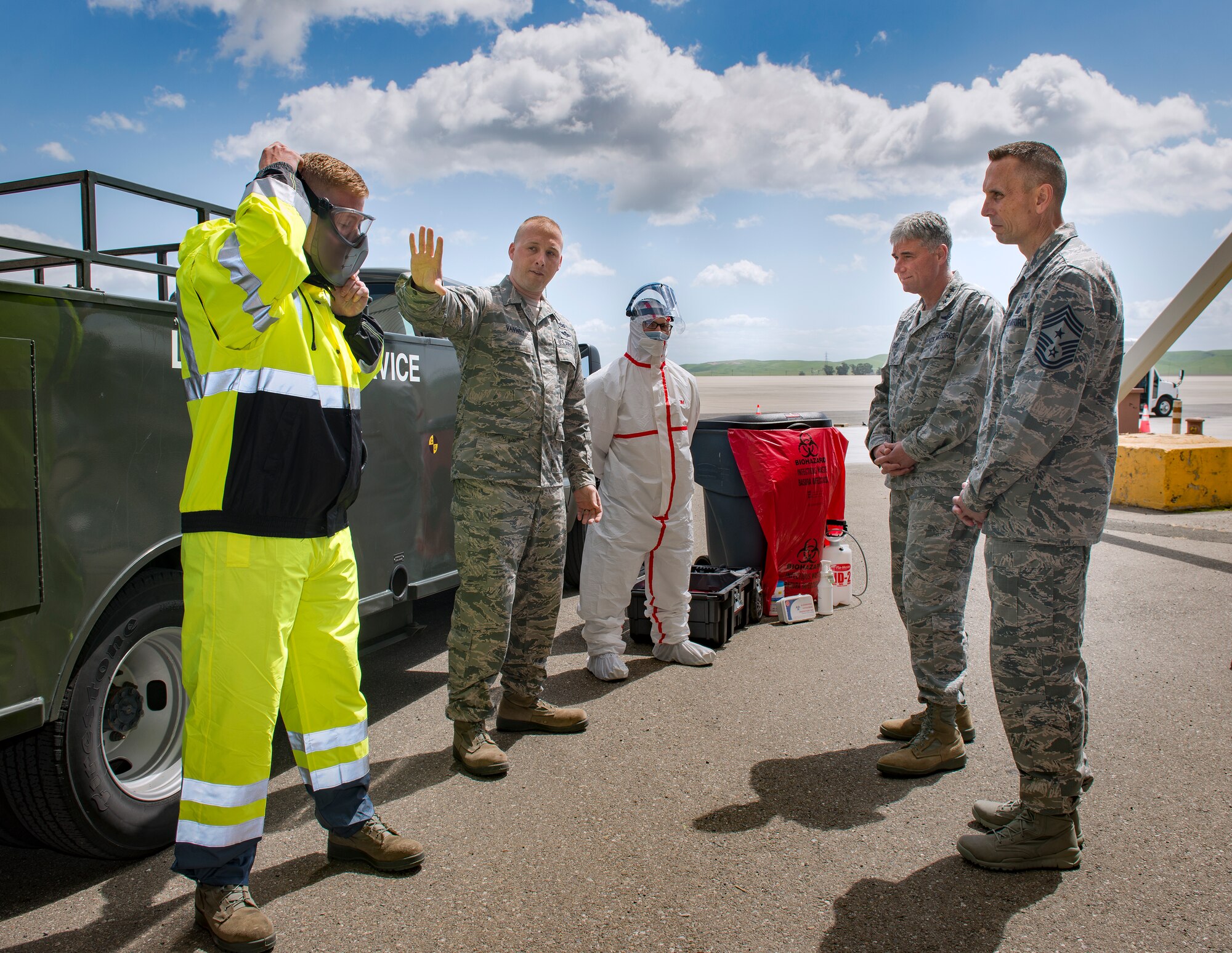 Staff Sgt. David Vanwhy, 60th Aerial Port Squadron fleet supervisor,
highlights new and improved safety gear April 14 at Travis Air Force Base,
California, to Lt. Gen. Sam Cox, 18th Air Force commander, and Chief Master
Sergeant Todd Petzel, 18th AF command chief. The suit serves as a barrier to
protect from anyone coming in contact with human waste, which could
potentially carry diseases. (U.S. Air Force Photo by Heide Couch/Released)

