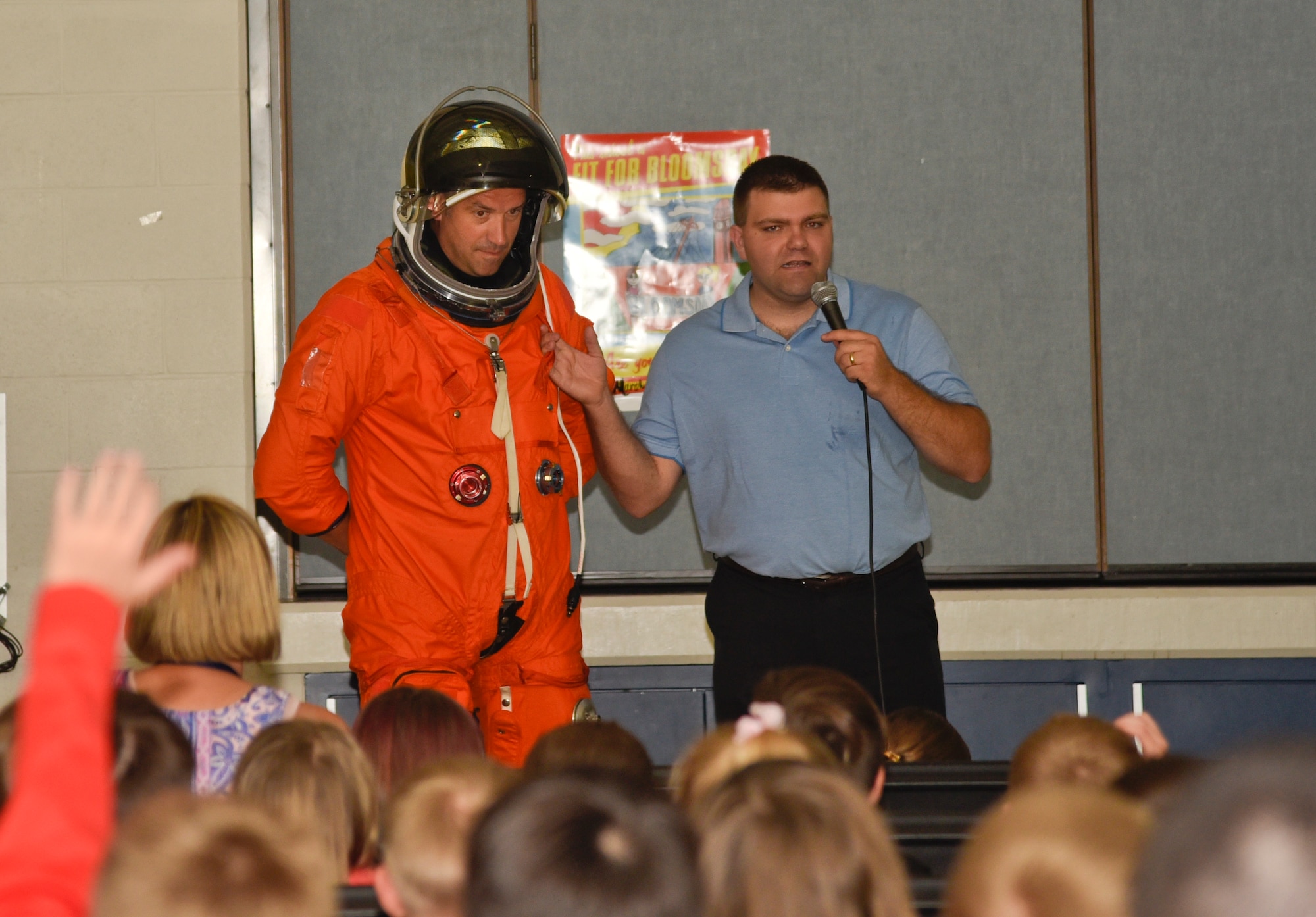 Lt. Col. Chas Tacheny, NASA Human Space Flight Support-Houston, Chief, wears an astronaut suit as Cody Kelly, NASA engineer, explains how it works April 20, 2016, at Michael Anderson Elementary School on Fairchild Air Force Base, Wash. The astronauts spoke to students about what it is like in space and answered questions from the students. (U.S. Air Force photo/Airman 1st Class Taylor Bourgeous)