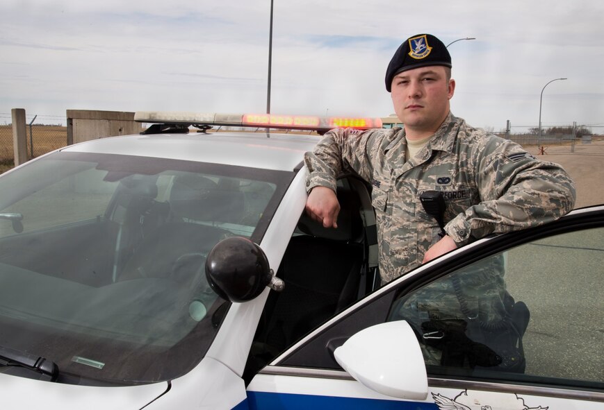 Senior Airman Eric Gagne, 5th Security Forces Squadron law enforcement patrolman, poses by his patrol vehicle at Minot Air Force Base, N.D., April 14, 2016. Gagne is one of several patrolmen who help keep Minot and its assets safe and secure. (U.S. Air Force photo/Airman 1st Class Christian Sullivan)