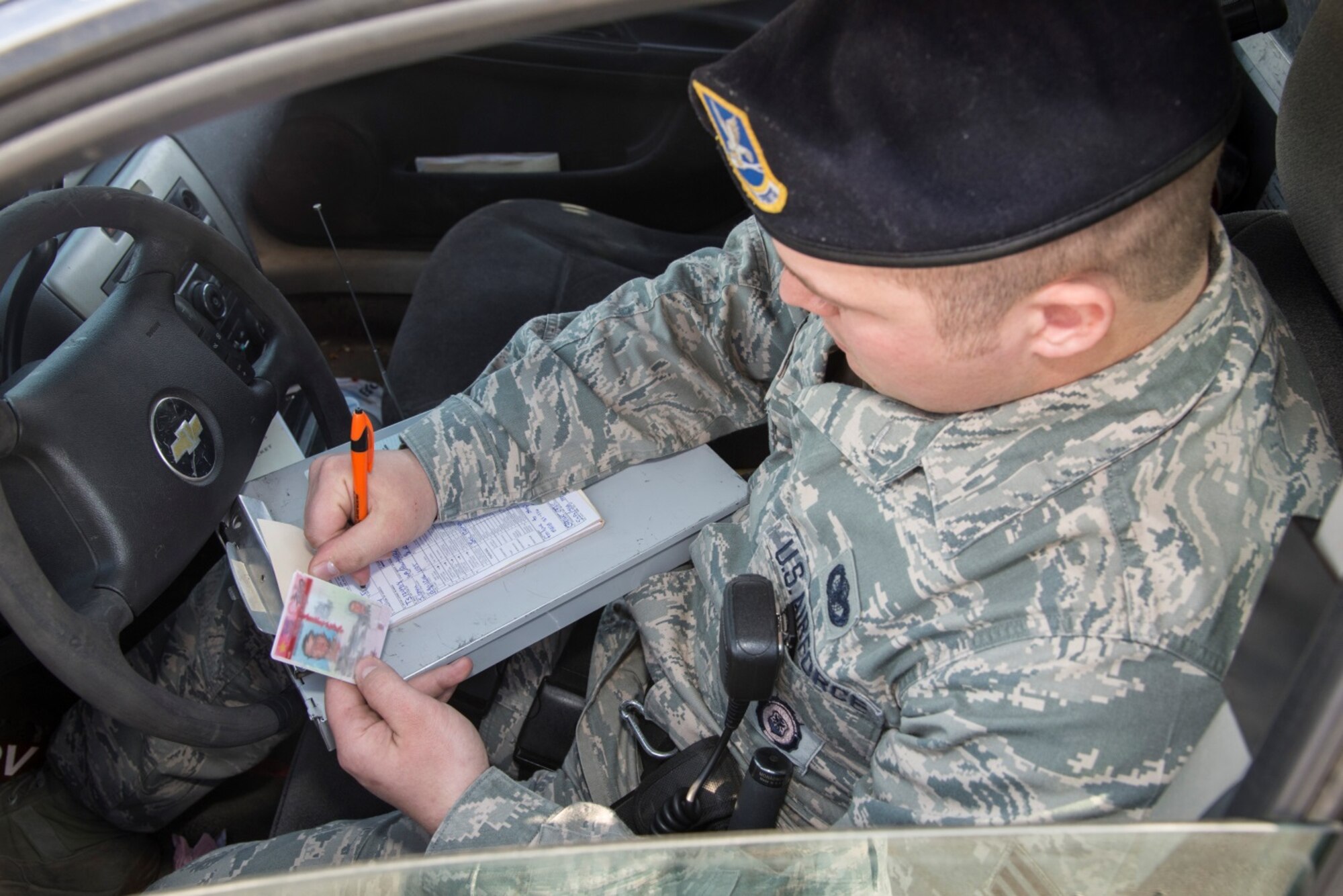 Senior Airman Eric Gagne, 5th Security Forces Squadron law enforcement patrolman, writes a ticket for a traffic violation at Minot Air Force Base, N.D., April 14, 2016. Gagne is one of several patrolmen who help keep Minot and its assets safe and secure. (U.S. Air Force photo/Airman 1st Class Christian Sullivan)