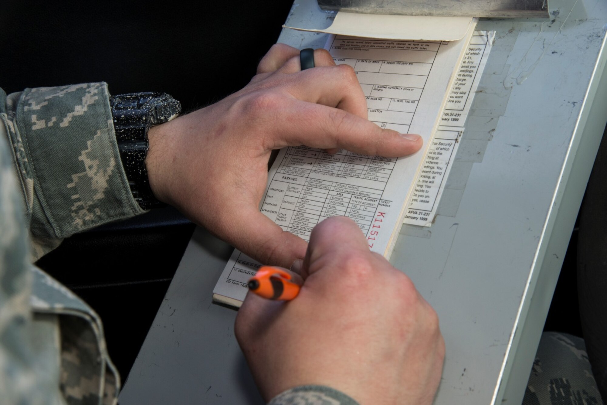 Senior Airman Eric Gagne, 5th Security Forces Squadron law enforcement patrolman, writes a ticket at Minot Air Force Base, N.D., April 14, 2016. Gagne is one of several patrolmen who help keep Minot and its assets safe and secure. (U.S. Air Force photo/Airman 1st Class Christian Sullivan)