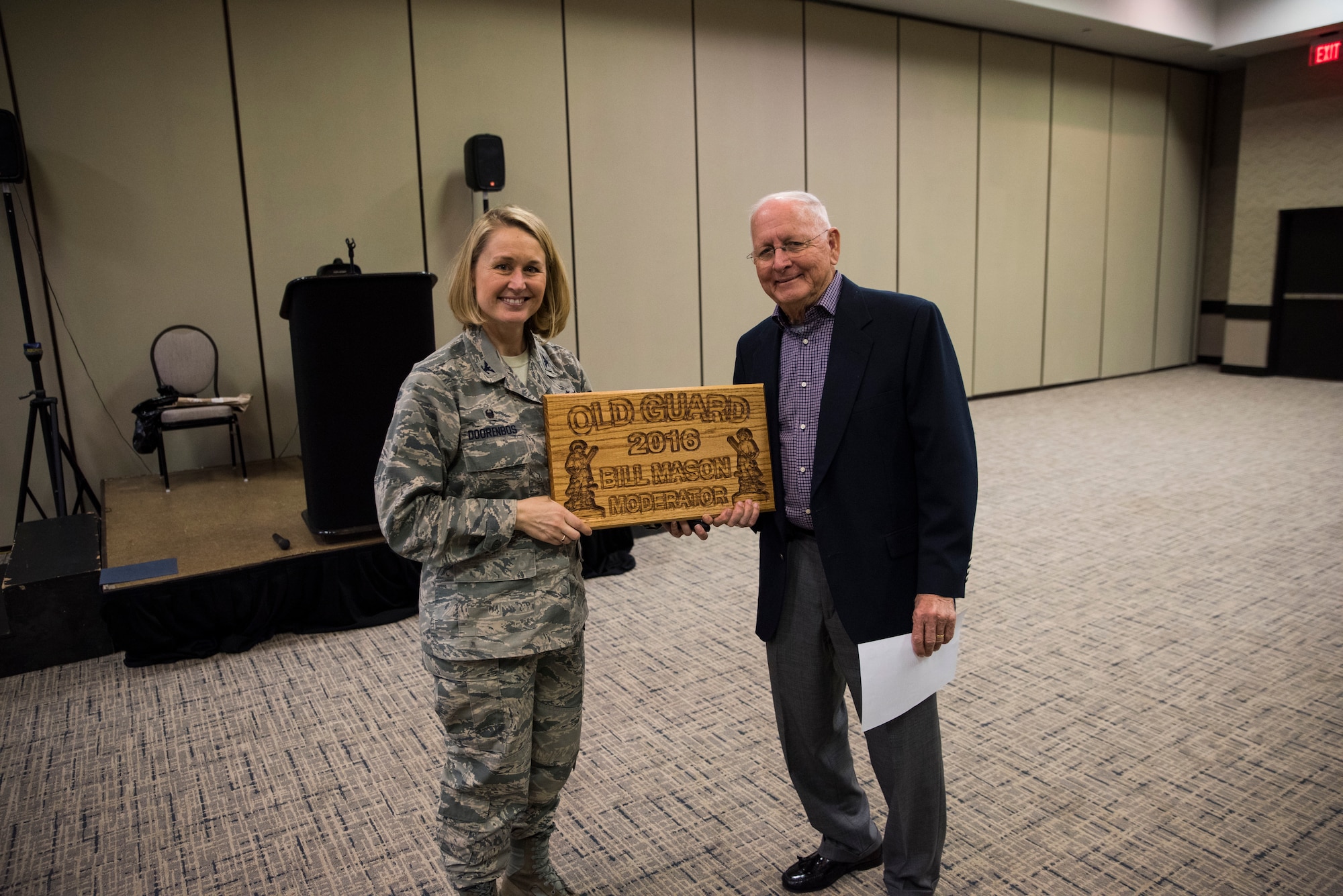 Col. Bobbi Doorenbos, 188th Wing commander, provided a plaque to Bill Mason for his role as the moderator March 31, 2016, during a breakfast held at the Executive Hotel at City Center in Fort Smith, Ark. The Old Guard showcased a new logo during the breakfast, which was developed to establish an identity and to have visual recognition. (U.S. Air National Guard photo by Tech. Sgt. Chauncey Reed/Released)