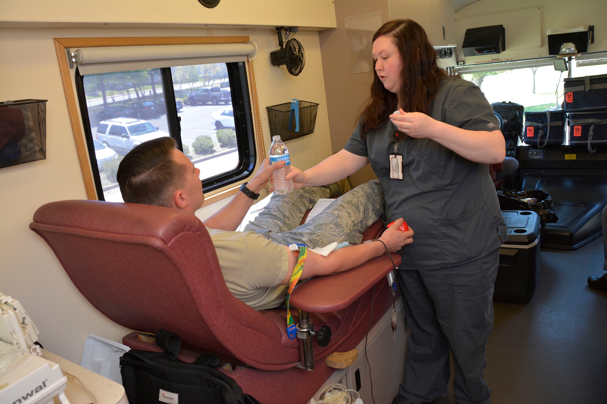 U. S. Air Force Senior Airman Daniel Monahan, crew chief for the 145th Aircraft Maintenance Squadron, gets water from Amanda Richardson, a member of the Community Blood Center of the Carolinas bloodmobile team, during a blood drive held at the North Carolina Air National Guard Base, Charlotte Douglas International Airport, April 9, 2016. The blood donated by Airmen through CBCC stays in the community helping patients in local hospitals. (U.S. Air National Guard photo by Master Sgt. Patricia F. Moran/Released)