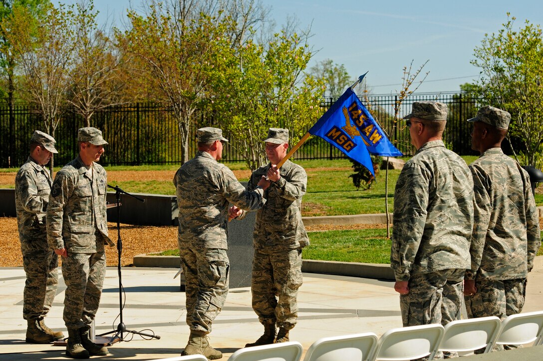 U.S. Air Force Col. Marshall C. Collins (left), commander, 145th Airlift Wing, passes the 145th Mission Support Group (MSG) guidon to Col. Russell Ponder (right) signifying his assumption of command of the MSG during a ceremony held at the North Carolina Air National Guard Base, Charlotte Douglas International Airport, April 9, 2016. The passing of the guidon is a long standing military tradition to signify a change in leadership and is a tradition carried on today. (U.S. Air National Guard photo by Staff Sgt. Julianne M. Showalter/Released)