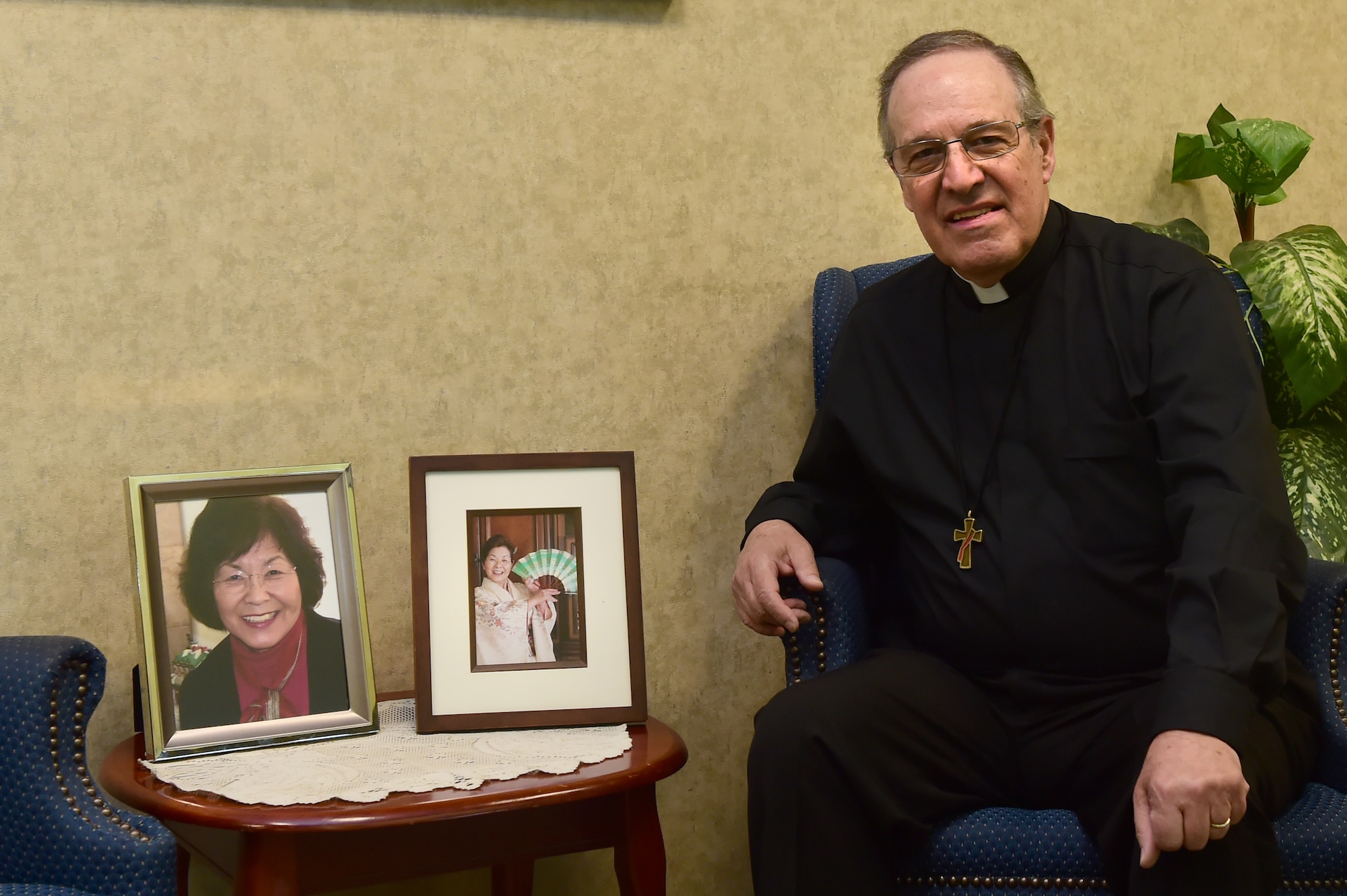 Deacon Craig Fucci, 460th Space Wing Chapel Catholic religious education coordinator, poses with photos of his wife Masae Fucci April 13, 2016, at the Buckley Chapel on Buckley Air Force Base, Colo. Fucci has been a deacon at Buckley AFB for over two years and helps with the Catholic Mass and religious education. (U.S. Air Force photo by Airman 1st Class Luke W. Nowakowski/Released)