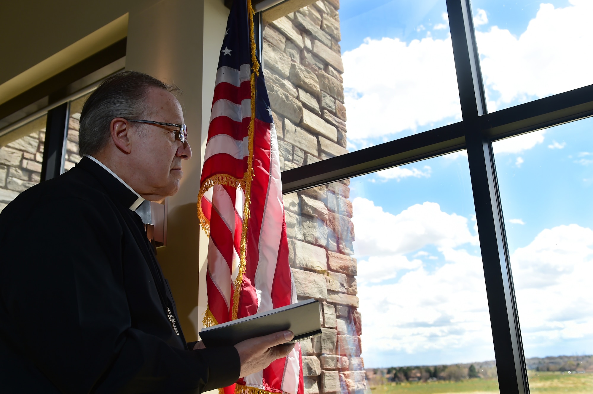 Deacon Craig Fucci, 460th Space Wing Chapel Catholic religious education coordinator, looks out onto Buckley Air Force Base, Colo. April 12, 2016, at the Buckley Chapel. Fucci teaches religious education, conducts Catholic Mass and counsels people looking for help. (U.S. Air Force photo by Airman 1st Class Luke W. Nowakowski/Released)
