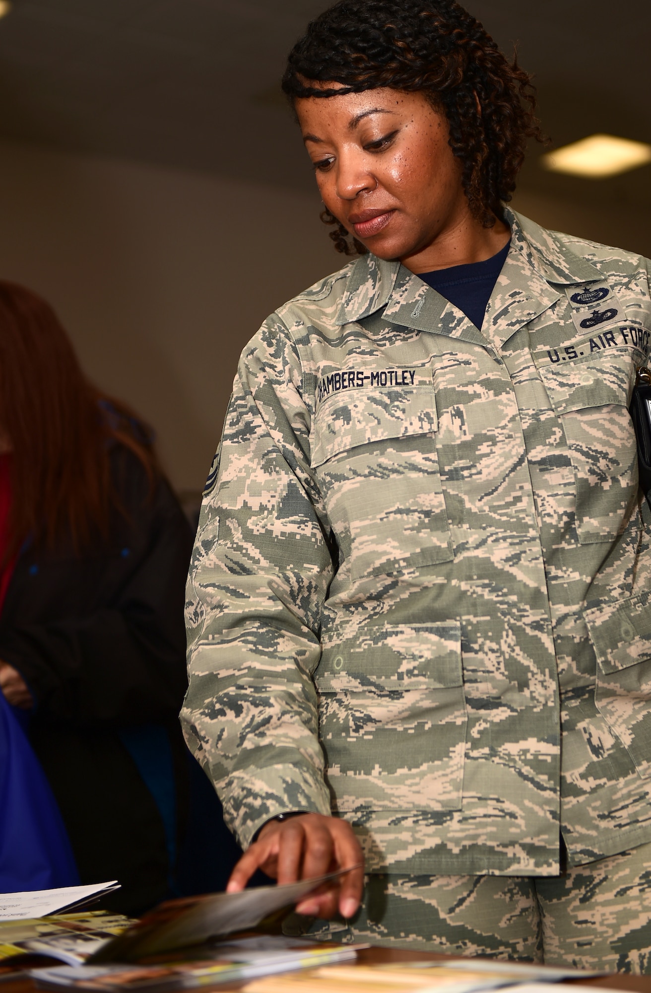Master Sgt. Pourshia Chambers-Motley, 460th Force Support Squadron Airman and Family Readiness Center NCO in charge, looks through brochures during a Child Abuse Awareness Month information fair April 15, 2016, on Buckley Air Force Base, Colo. Children who are being abused or neglected may display constant alertness, sudden changes in behavior and school performance, or untreated physical or medical issues. (U.S. Air Force photo by Senior Airman Racheal E. Watson/Released) 