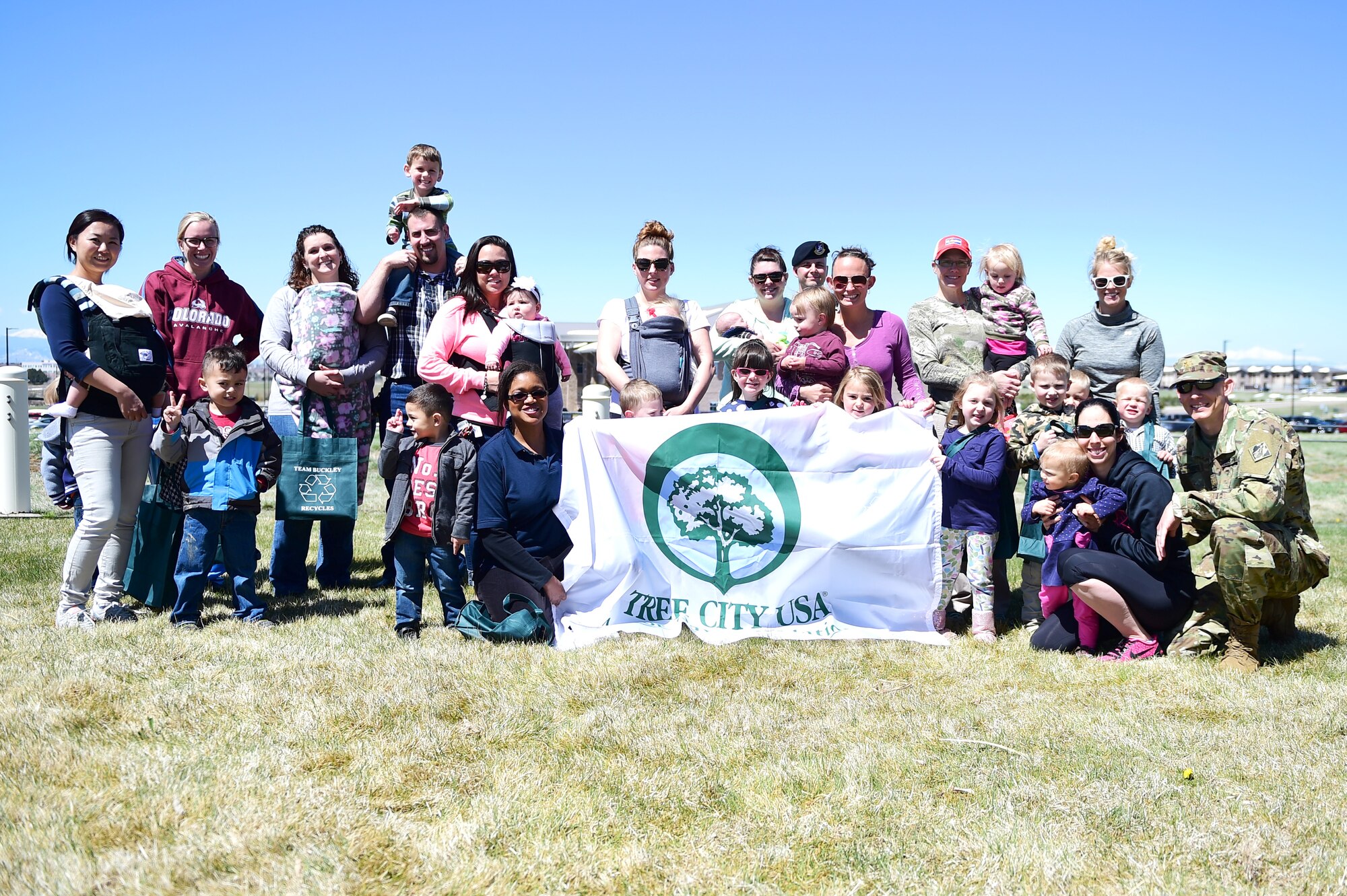 Parents and children from A-Basin Child Development Center gather together during an Earth and Arbor Day celebration April 21, 2016, on Buckley Air Force Base, Colo. Trees isolate carbon that would otherwise end up in the atmosphere, warming Earth, and provides shade that lowers the need for air conditioning. (U.S. Air Force photo by Senior Airman Racheal E. Watson/Released)