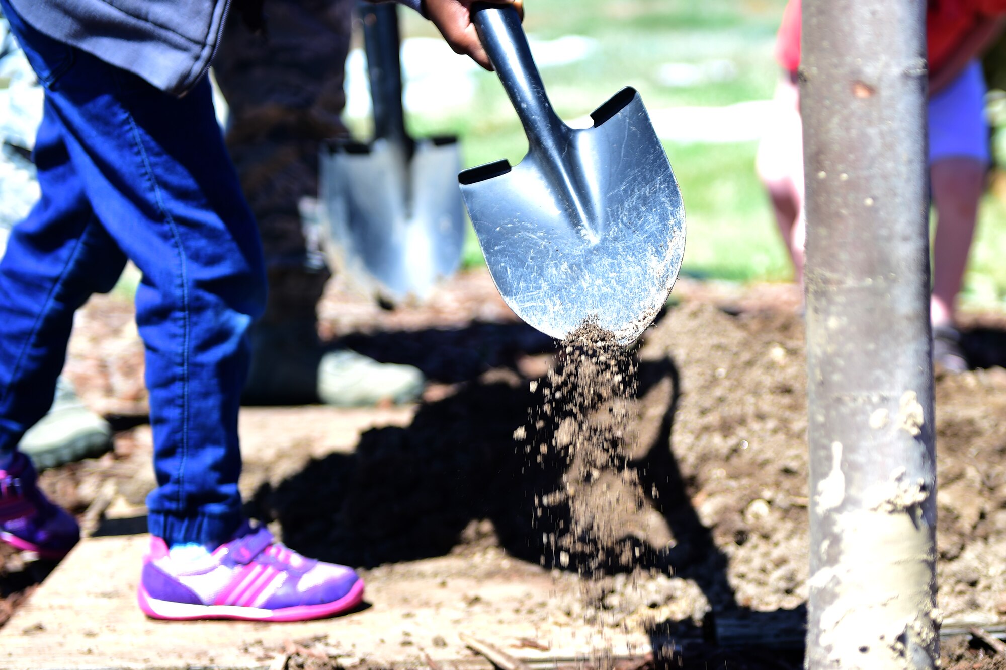 A child from A-Basin Child Development Center shovels dirt onto the newly planted tree during an Earth and Arbor Day celebration April 21, 2016, on Buckley Air Force Base, Colo. The fight for a cleaner environment continues with increasing urgency, as the ravages of climate change become more manifest every day. (U.S. Air Force photo by Senior Airman Racheal E. Watson/Released)