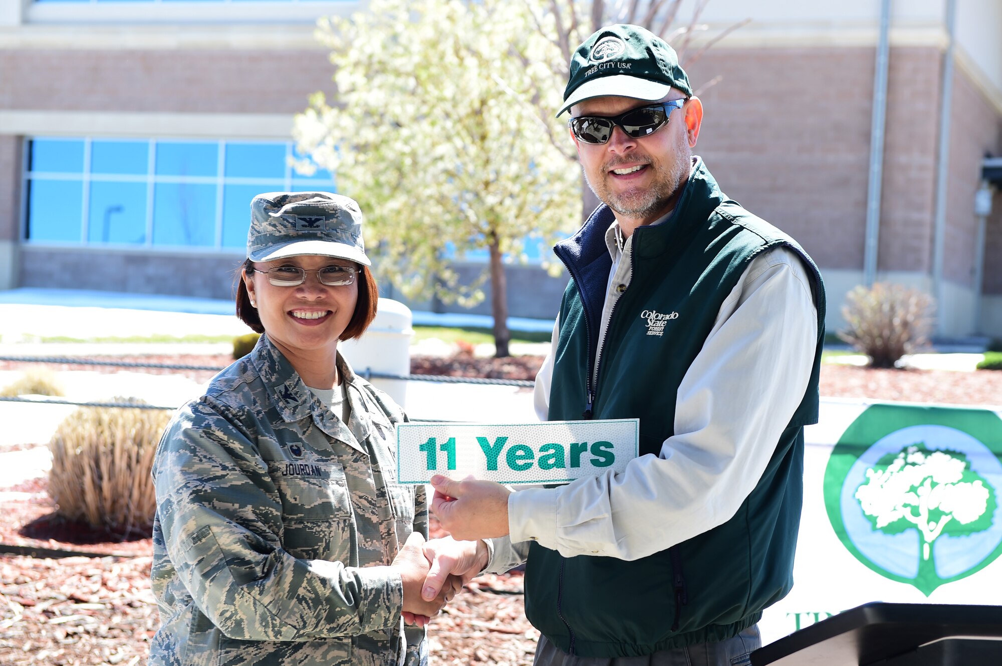 Col. Rose Jourdan, 460th Mission Support Group commander, receives a sticker from Keith Wood, forester for the Community Forestry Division Colorado State Service during an Earth and Arbor Day celebration April 21, 2016, on Buckley Air Force Base, Colo. This year celebrated Buckley’s 11th year of qualifying for Tree City USA, a nationwide movement that provides the framework necessary for communities to manage and expand their public trees. (U.S. Air Force photo by Senior Airman Racheal E. Watson/Released)