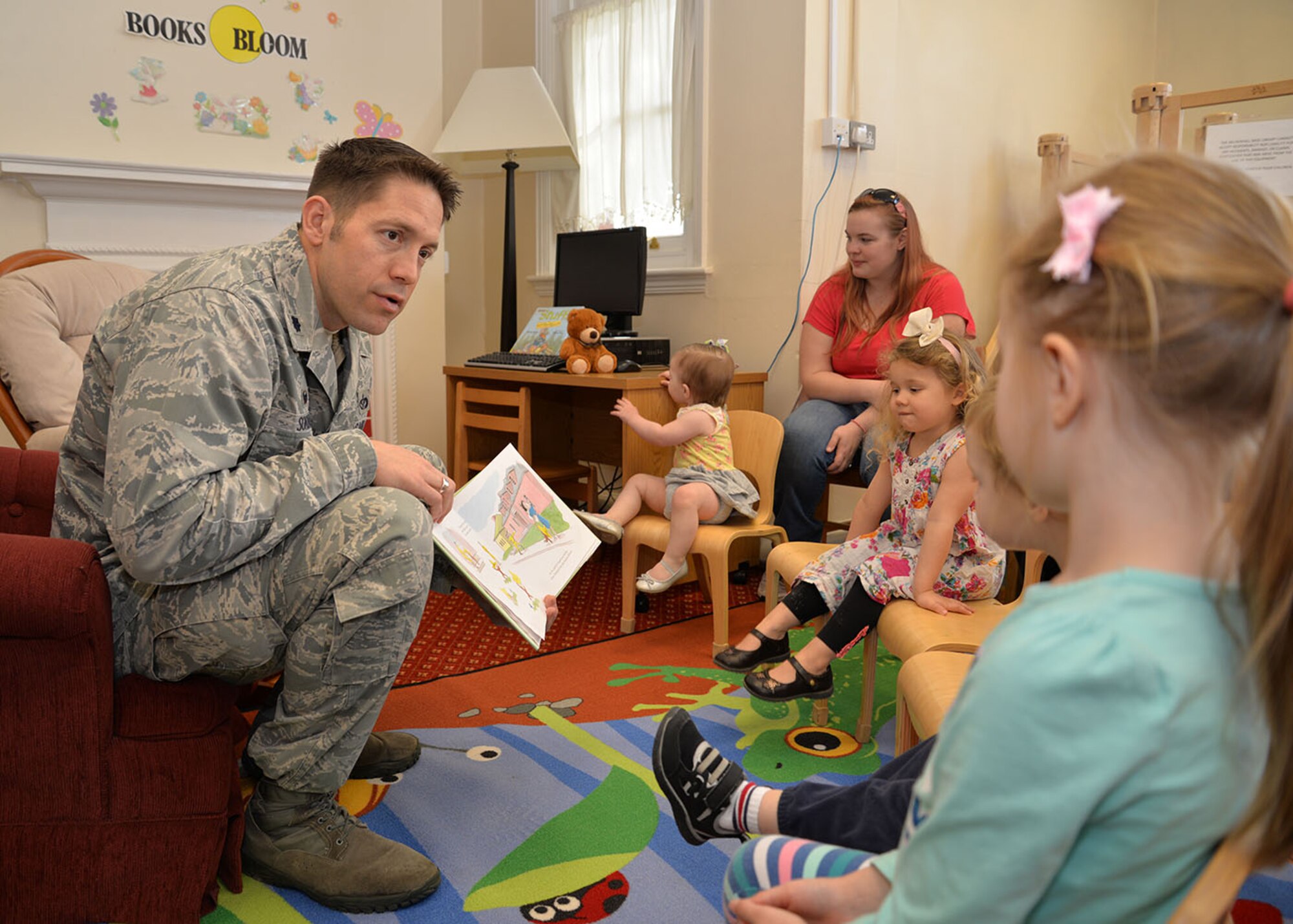 U.S. Air Force Lt. Col. Brandon Sokora, 100th Civil Engineer Squadron commander, reads Earth Week-themed stories to children April 20, 2016, at the library on RAF Mildenhall, England. Storytime was one of several events held April 15 to 22 to celebrate Earth Week. (U.S. Air Force photo by Karen Abeyasekere/Released)