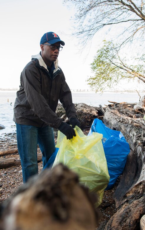 Maj. Ernest Cage, 11th Logistics Readiness Squadron commander, moves a bag of trash to the trail head along the Potomac River shore in Fort Washington, Md., April 16, 2016. Members of Joint Base Andrews helped clean up the shore in commemoration of Earth Day. (U.S. Air Force photo by Airman Gabrielle Spalding/Released)