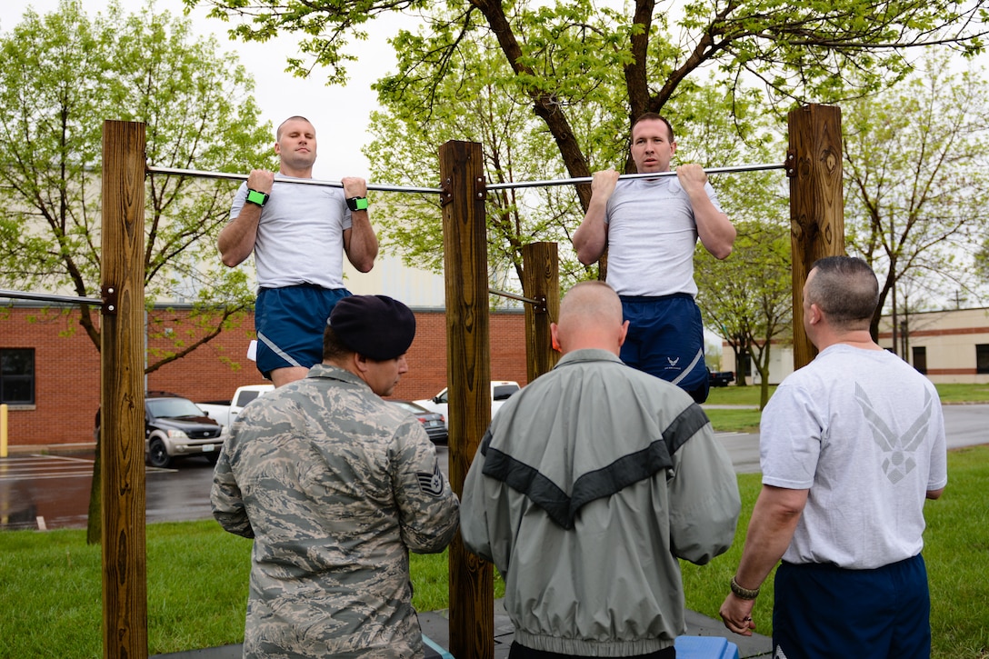 U.S. airmen assigned to the 139th Airlift Wing, Missouri Air National Guard, perform pull-up hangs during a German Armed Forces Badge for Military Proficiency test at Rosecrans Air National Guard Base, St. Joseph, Mo., April 20, 2016. Airmen and soldiers qualify in various events including running, swimming, sprints, pull-up hang, pistol marksmanship, and a ruck march. Participates may qualify in bronze, silver, or gold categories. (U.S. Air National Guard photo by Senior Airman Bruce Jenkins/released)