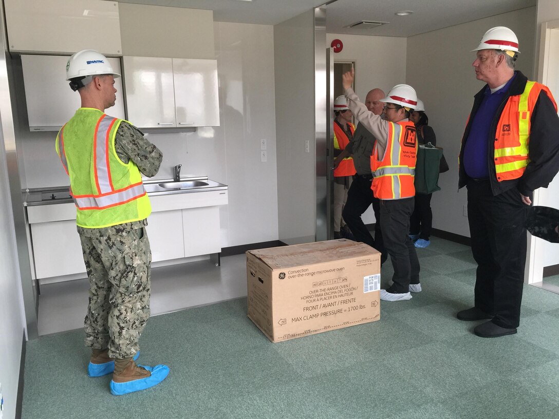 Kuniaki Nakamoto, U.S. Army Corps of Engineers Japan District Marine Corps Air Station Iwakuni Resident Office engineer, center, explains the layout of the kitchens in the new rooms of the Kintai Inn to Commander Jeffrey Pfeil, Facilities commander and Lawrence Seeba, Iwakuni Resident Office resident engineer. 