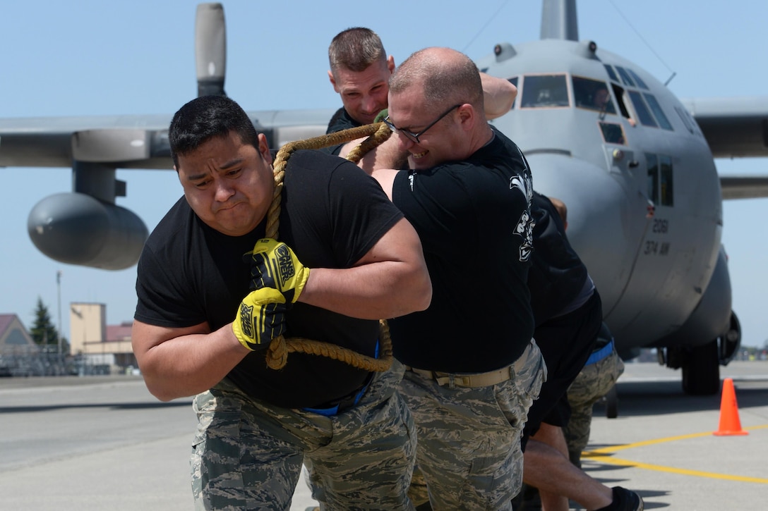 Airmen pull a C-130 Hercules during a competition at Yokota Air Base, Japan, April 15, 2016. The airmen are assigned to the 374th Maintenance Operations Flight. Air Force photo by Staff Sgt. Cody H. Ramirez