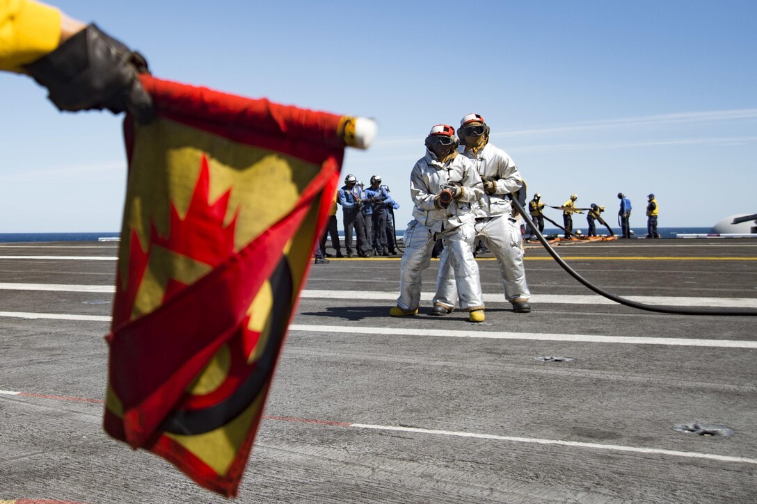 Sailors combat a simulated fire during a drill on the flight deck of the aircraft carrier USS Dwight D. Eisenhower in the Atlantic Ocean, April 10, 2016. The Eisenhower is underway preparing for an upcoming deployment. Navy photo by Petty Officer 3rd Class Anderson W. Branch