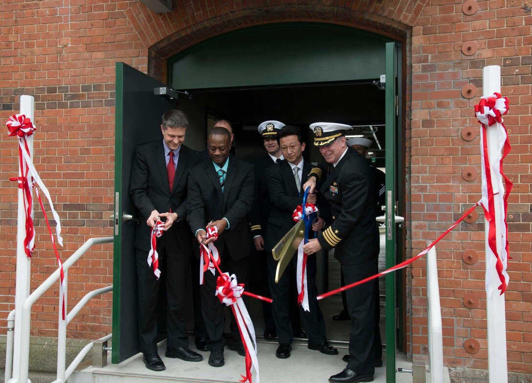 U.S. Consulate Fukuoka Principal Officer Yuriy Fedkiw, U.S Army Corps of Engineers, Japan District, Sasebo Resident Engineer Don George, Sasebo Defense Office Chief Kenji Nakasuji and Commander U.S. Fleet Activities Sasebo Capt. Matthew Ovios cut the ribbon officially commissioning Building 311 on Commander Fleet Activities Sasebo, Japan as the new regional telecommunications exchange and service center. (U.S. Navy photo by Mass Communication Specialist 1st Class David R. Krigbaum)