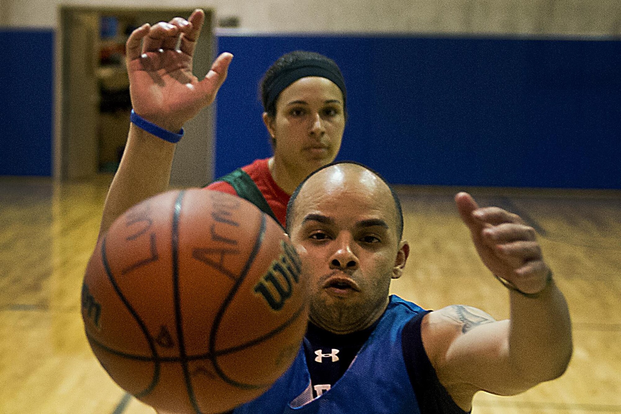Mario Cruz, 434th Security Forces Squadron ‘A’ team, rushes past Kaila Walker, 434th Logistics Readiness Squadron team, to stop the ball from going out of bounds during the final round of Grissom’s annual basketball tournament April 9, 2016 at Grissom Air Reserve Base, Ind. LRS rallied from the loser’s bracket winning their final three games to take home the trophy. (U.S. Air Force photo/Senior Airman Dakota Bergl)